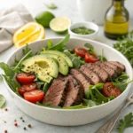 Low-carb steak salad featuring sliced steak, avocado, and cucumber on arugula